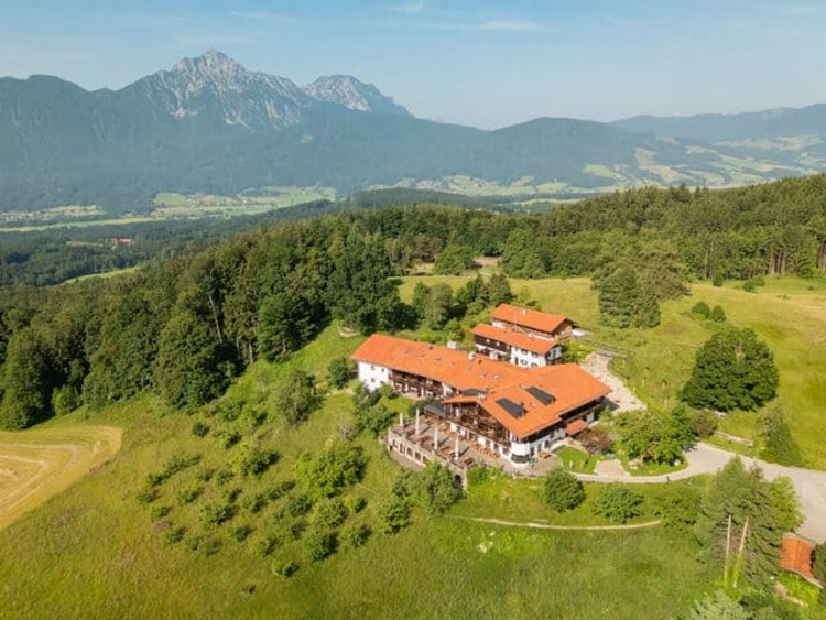 Luftaufnahme von der Neubichleralm bei Piding. Im Hintergrund Berge